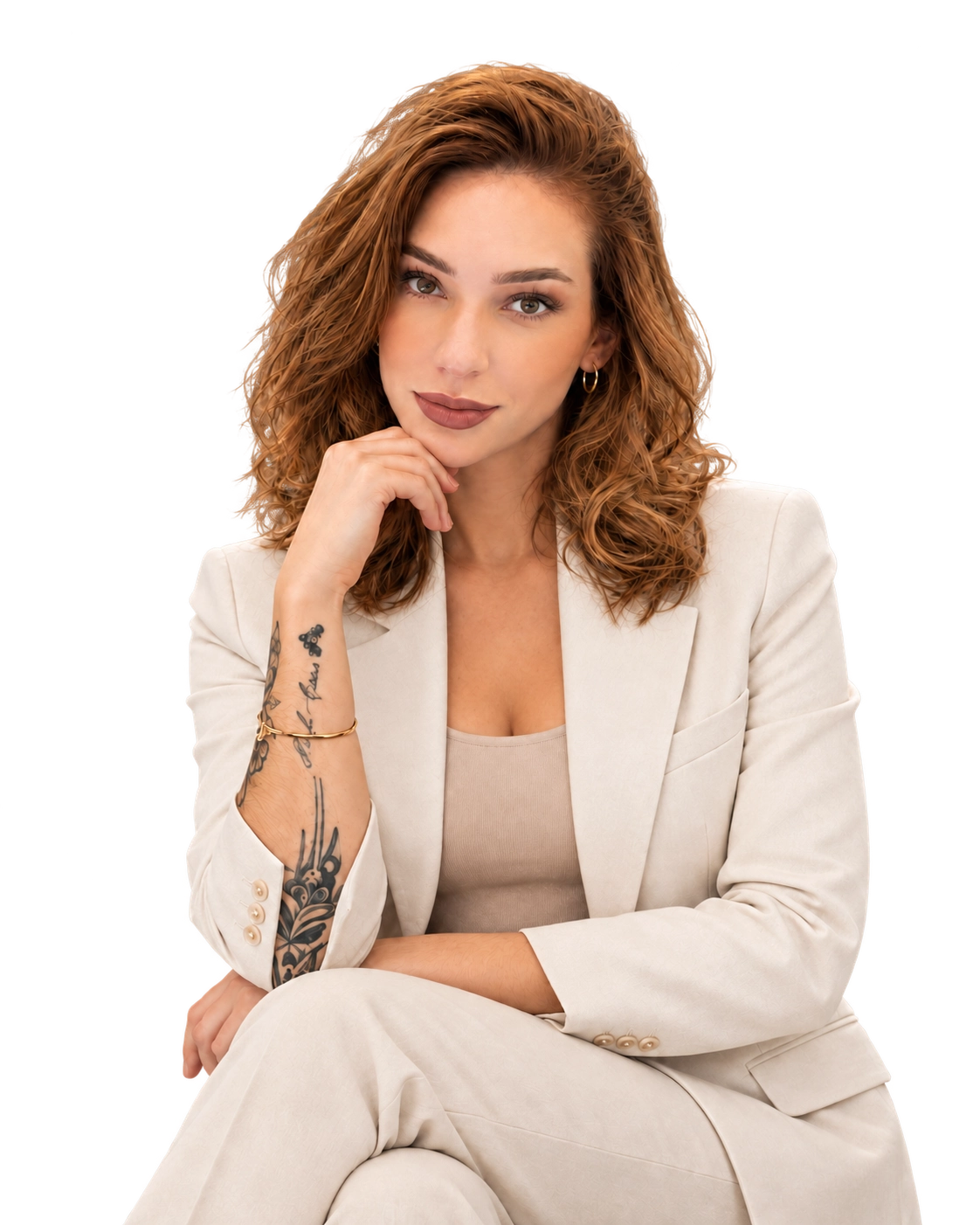 Pamela Moraes, sentada com a mão apoiada no queixo, vestindo blazer branco